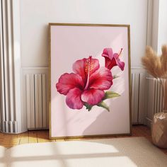 a pink flower is on the wall next to a potted plant