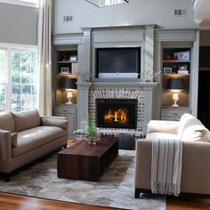 a living room filled with furniture and a fire place in the middle of a fireplace