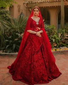 a woman in a red wedding dress standing outside