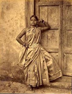 an old photo of a woman leaning against a door with her hands on her head