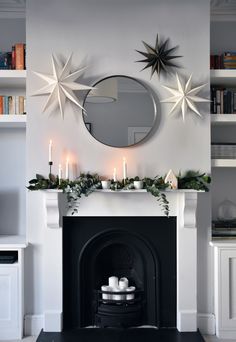 the fireplace is decorated with candles and decorations