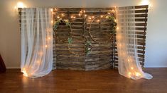 the room is decorated with string lights and wooden slats, along with sheer curtains