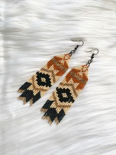 How about adding a touch of Southwestern charm to your style with these stunning beaded fringe earrings? These earrings are meticulously crafted with love and attention to detail, featuring a beautiful Southwestern inspired design that captures the essence of the desert. Each bead is carefully chosen and skillfully woven to create a fringe effect that adds movement and flair. Whether you're a fan of the Southwest aesthetic, a lover of Native American art, or simply want to make a statement with your accessories, these earrings are perfect for you. Embrace the spirit of the Southwest and let these fringe earrings elevate your style.  *Features: set of two (2) nickel free fish-hook style earring with rubber backing *Hand beaded  *High quality materials *Measures approximately 3.5"x1.25" Let' Southwestern Crafts Diy, Native American Fringe Earrings Pattern, Western Beaded Fringe Earrings, Western Beaded Earrings, Southwest Aesthetic, Western Earring, Hand Beaded Earrings, Earrings Western