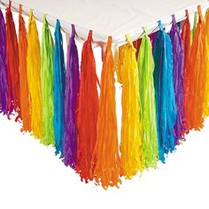 a white table topped with colorful streamers and tassels on top of it