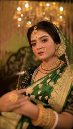 a woman wearing a green and gold bridal outfit