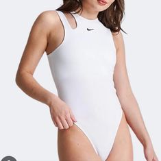 a woman in a white bodysuit with her hands on her hips