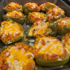 several stuffed peppers in a pan with cheese on them