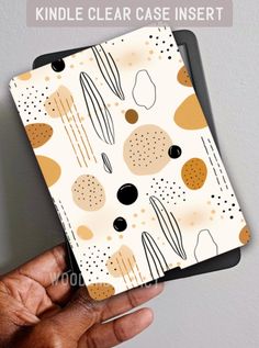 a hand holding an ipad case in front of a white background with circles and dots