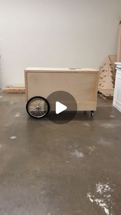 an empty room with a bike on the floor and some boxes in the back ground