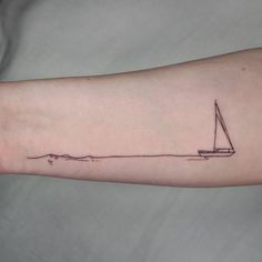 a small sailboat tattoo on the arm