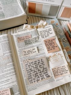 an open book with stickers on top of it next to some books and pens