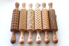 six wooden spoons lined up next to each other on a white surface with measurements