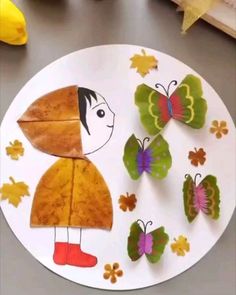 a paper plate with butterflies on it and a child's face cut out in the middle