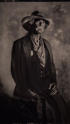 an old black and white photo of a man wearing a hat