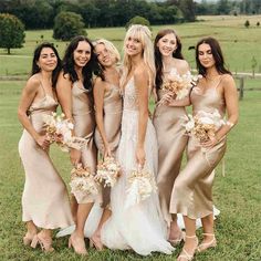 a group of women standing next to each other on top of a lush green field