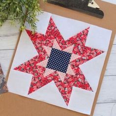 a red, white and blue quilted star sitting on top of a piece of paper