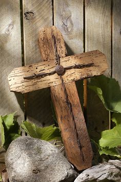 a wooden cross sitting on top of rocks