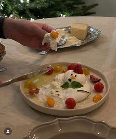 a plate with some food on it and a person holding a spoon in their hand