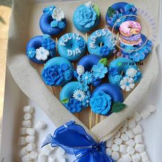 blue cupcakes are arranged in a heart shaped box