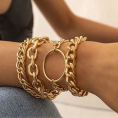 a woman wearing gold bracelets on her arm