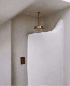 a white wall with a gold light hanging from it's side