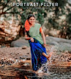 a woman in blue and green sari is splashing water into the river with her feet