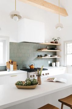 a kitchen with white counter tops and wooden shelves