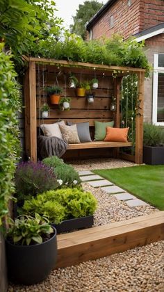 a small garden area with plants and seating on the side of the house, surrounded by graveled walkways