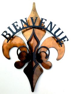 a metal fleur de l'oeuvre sign mounted to the side of a building