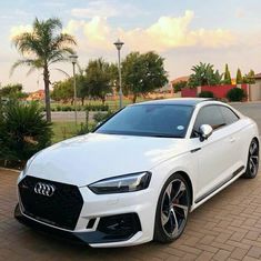 a white car parked in front of a house