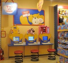 the children's store has two computers and toys on tables in front of them