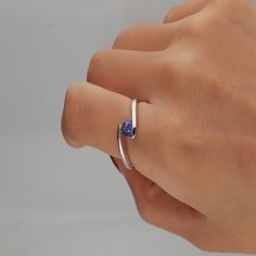 Gracefully coiling around the finger, this tanzanite triangle bypass ring exudes super-natural beauty. A tanzanite gemstone ring reveals tonal depth ranging from lilac-blue to deep-blue violet with exceptional contrast in sterling silver. | Tanzanite Triangle Bypass Ring | Sterling Silver | White | Size 7 | Helzberg Diamonds Triangle Tanzanite Ring, Bypass Rings, Blue Engagement Ring, Country Rings, Lilac Blue, Triangle Ring, Helzberg Diamonds, Bypass Ring, Tanzanite Ring