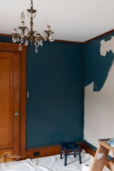 an empty room with blue walls and a chandelier