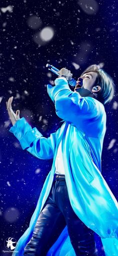 a male in a blue coat and black pants on stage with snow falling around him