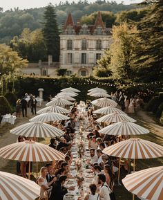 a group of people sitting at tables under umbrellas