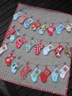 a quilted table cloth with baby's clothes hanging from it on a line