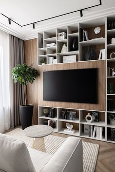 a living room filled with furniture and a large flat screen tv mounted on a wall