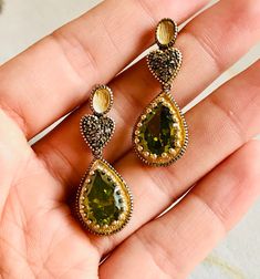 A beautiful vintage pair of drop earrings made of 9K yellow gold and silver set in three parts. On the top two oval-shaped studs, in the middle two hearts covered with rose-cut natural brown diamonds, and on the bottom two artificial green stones in teardrop shape. A lovely pair of earrings with a slight dangle.  In this pair of earrings, the brown diamonds are natural in rose cut and the green stones are synthetic yet very impressive.  Artificial gemstones are popular in jewelry manufacture sin Ornate Diamond Accent Drop Earrings, Elegant Green Earrings With Rose Cut Diamonds, Oval Yellow Gold Earrings With Rose Cut Diamonds, Vintage Drop Earrings With Matching Set, Ornate Gold Earrings With Diamond Accents, Ornate Diamond Accent Earrings For Anniversary, Ornate Diamond Accented Earrings For Anniversary, Vintage Drop Jewelry Set With Matching Earrings, Vintage Drop Earrings For Pierced Ears