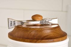 a wooden spoon sitting on top of a white jar filled with silverware and wood