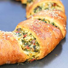 a close up of bread with spinach and cheese in it on a blue surface