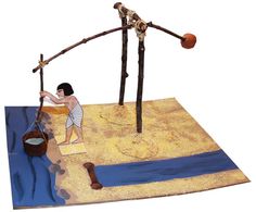 a paper model of a man standing in front of a body of water with two sticks sticking out of it