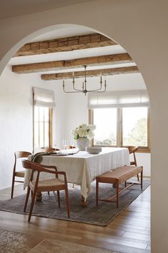 a dining room with a table and chairs in front of an archway leading to the outside