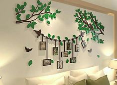 a living room with a white couch and green tree wall decals on the wall