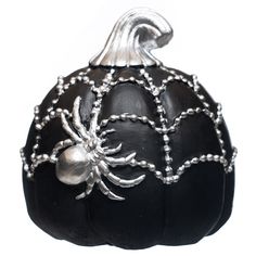 a black pumpkin decorated with silver beads and a spider on it's side, sitting in front of a white background