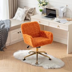 an orange chair sitting on top of a white rug in front of a desk with a laptop