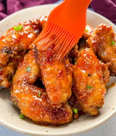 a close up of a plate of food with chicken wings and ketchup on it