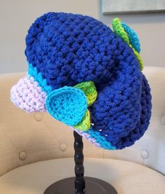 a crocheted blue hat sitting on top of a white chair