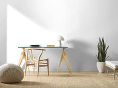 a room with a table, chair and potted plant on the floor next to it