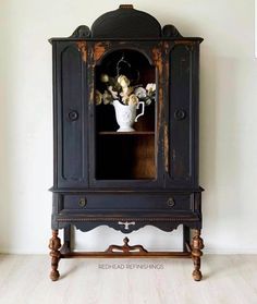 an old china cabinet with flowers in it