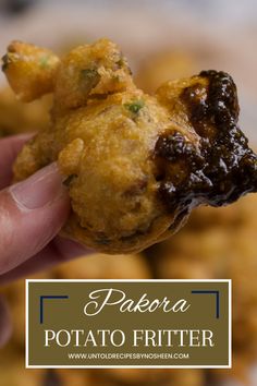 a hand holding up a fried potato fritter with the words pakora potato fritter on it